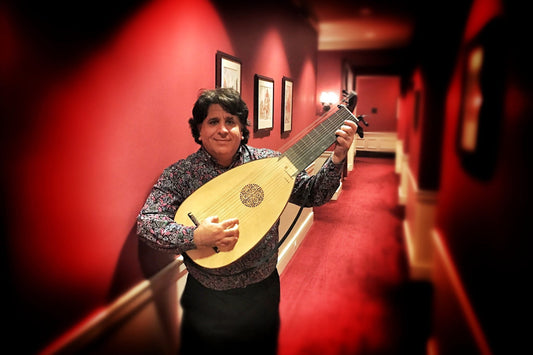 Portrait de Matthew Weinman tenant un luth baroque LLD® 13c, dans le Harvard Club de New York.