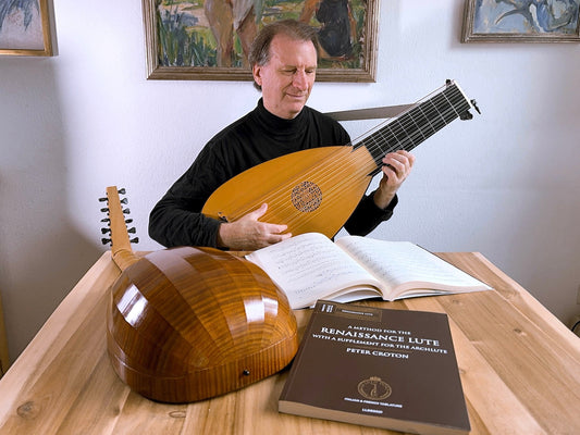 Peter Croton joue du luth Baroque avec les éditions Urtext Le Luth Doré sur la table.